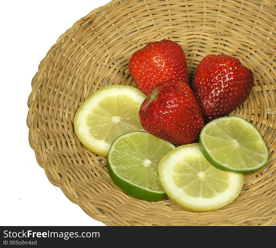 Strawberries,lemon and limes on a woven platter. Strawberries,lemon and limes on a woven platter