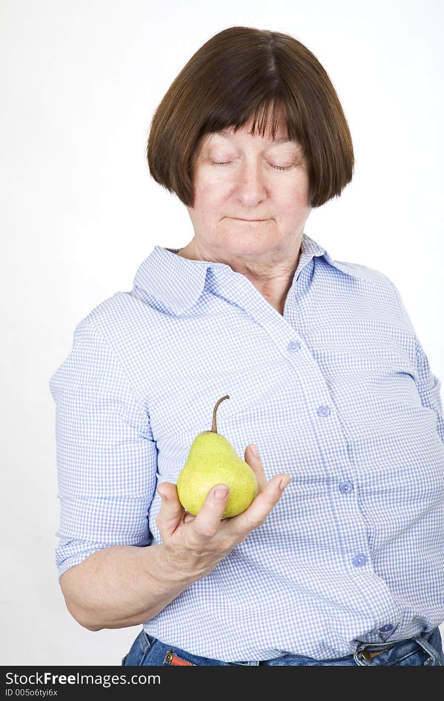 Senior lady holding a pear. Senior lady holding a pear