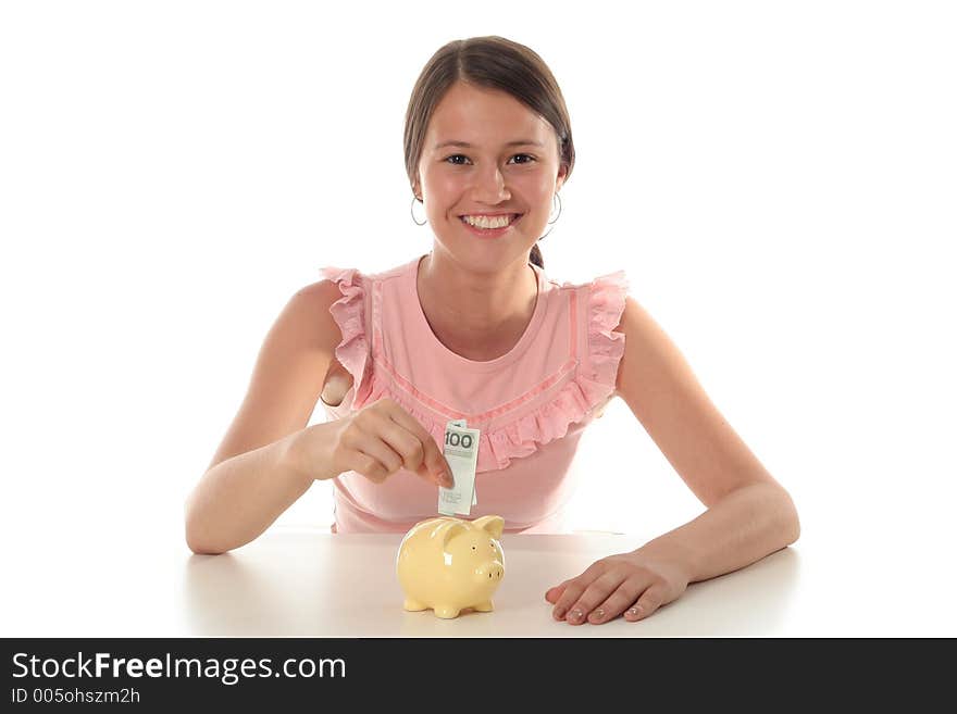 Woman Putting Money In Piggy Bank