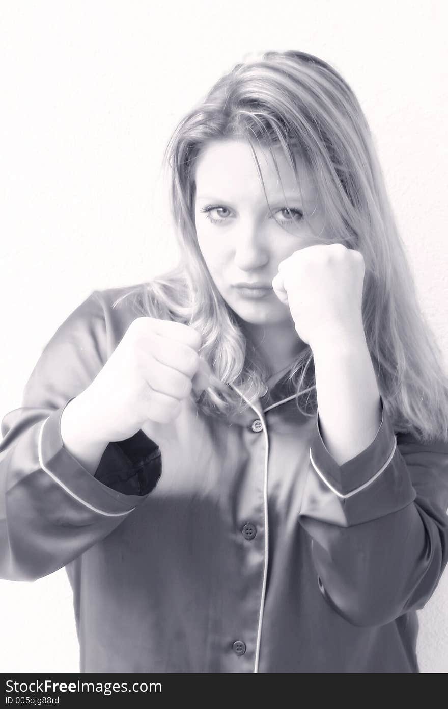 A young woman focused and ready to fight with a lot of attitude.. Control, concentration & contemplation. .She's holding her fists up, staring at camera and preparing to punch.. attractive, sexy,tough & feminine Monochrome image. A young woman focused and ready to fight with a lot of attitude.. Control, concentration & contemplation. .She's holding her fists up, staring at camera and preparing to punch.. attractive, sexy,tough & feminine Monochrome image