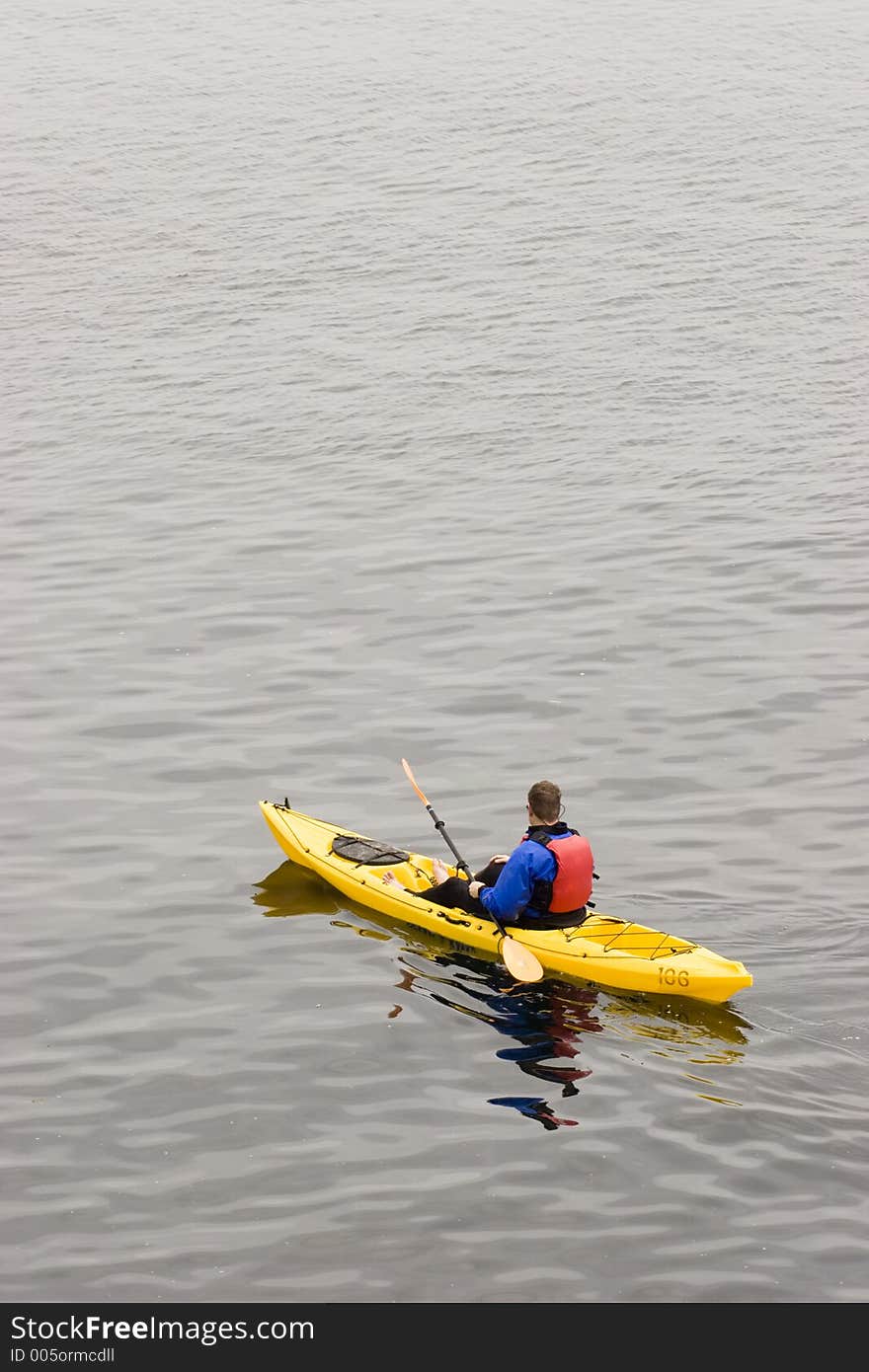 A man kayaks on the ocean. A man kayaks on the ocean