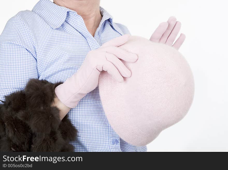 Lady's hands holding a pink hat, wearing pink gloves