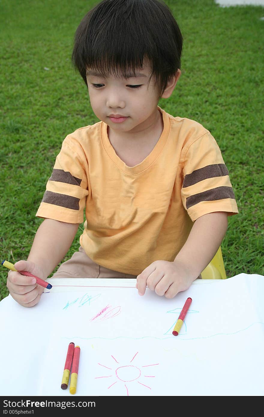 Boy draws with crayon