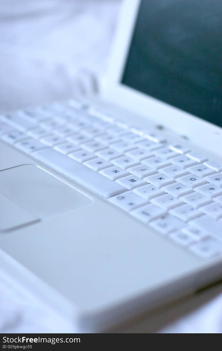 White laptop on top of white sheet. White laptop on top of white sheet