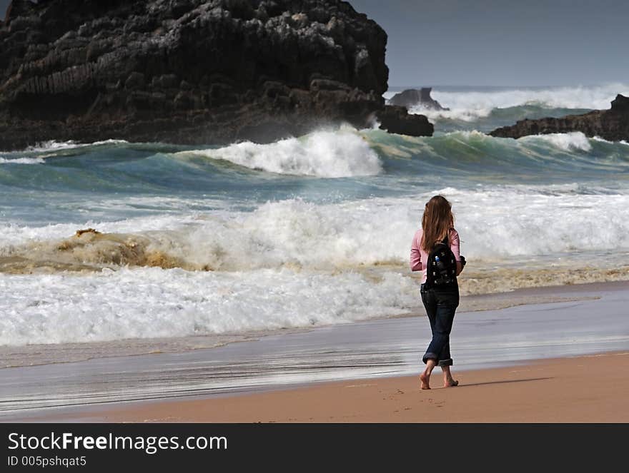 Girl walking on the beach barefoot