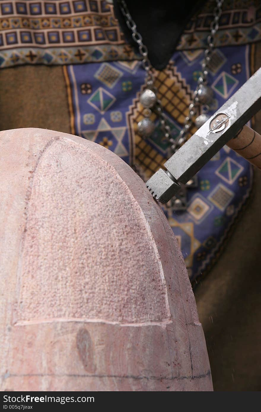 Shot of craftsman working stone the old fashioned way with hammer and chisel. Shot of craftsman working stone the old fashioned way with hammer and chisel