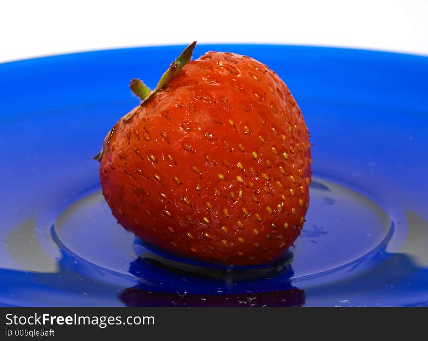 Strawberry on blue glass dish