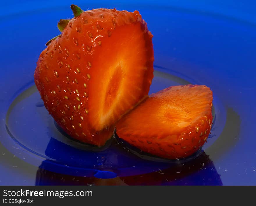 Sliced strawberry on blue glass dish