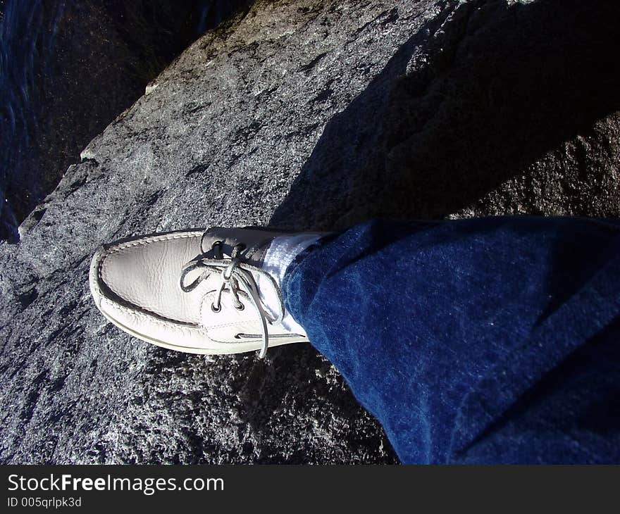 Standing on the edge of a rock with the ocean below