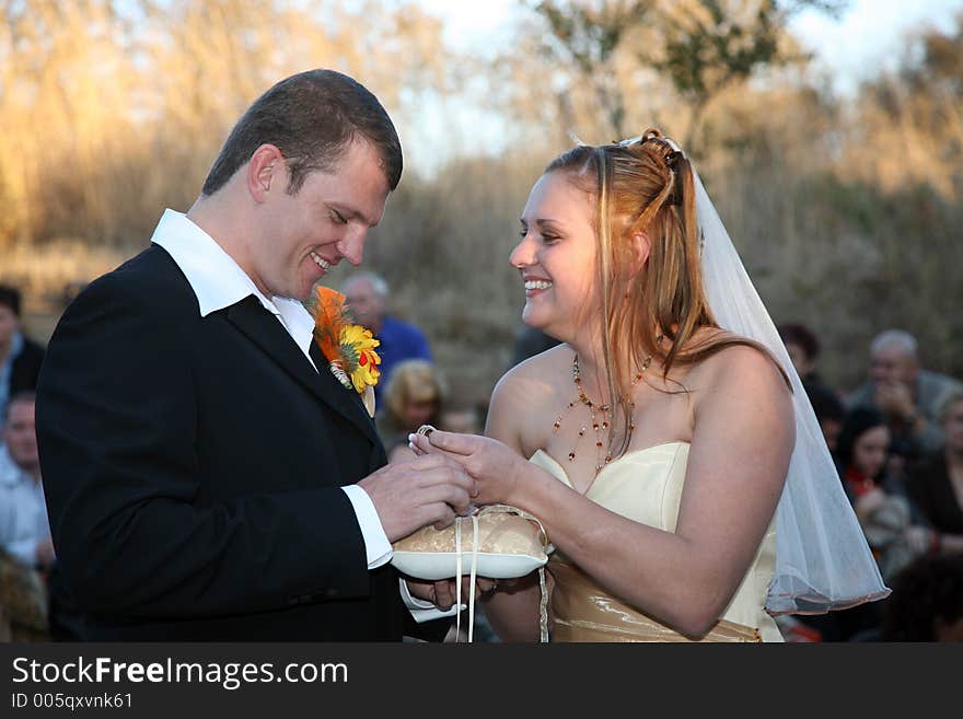 Bride smiling at groom, holding her ring. Bride smiling at groom, holding her ring