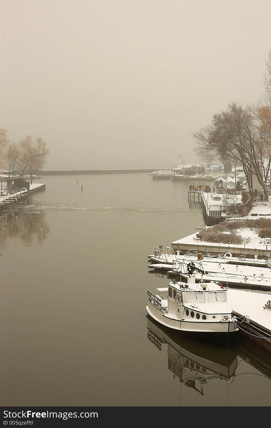 Grey skies and still water in a winter harbor view. Grey skies and still water in a winter harbor view.