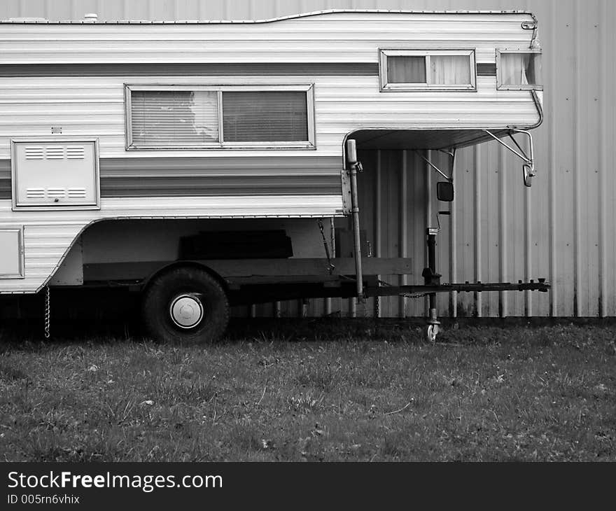 Mobile home or camping shell in black and white against a corrugated aluminum wall. Mobile home or camping shell in black and white against a corrugated aluminum wall.