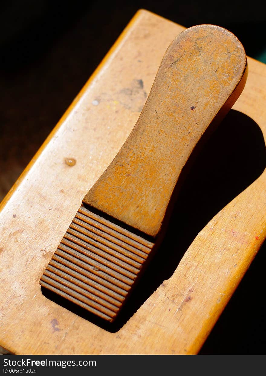 Vintage wooden shoe-polishing station illuminated in the midst of deep shadow. Vintage wooden shoe-polishing station illuminated in the midst of deep shadow.