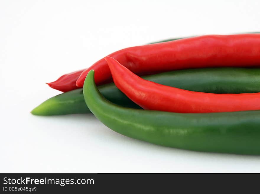 Red banana chilli peppers isolated on white, with green stalk, macro, close up. Red banana chilli peppers isolated on white, with green stalk, macro, close up