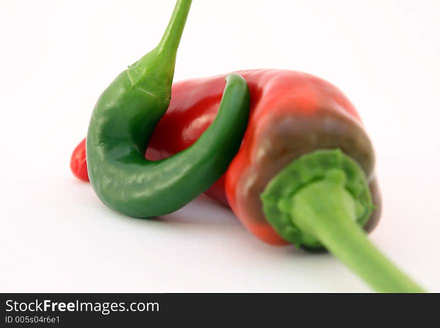 Red banana chilli peppers isolated on white, with green stalk, macro, close up, shallow dof