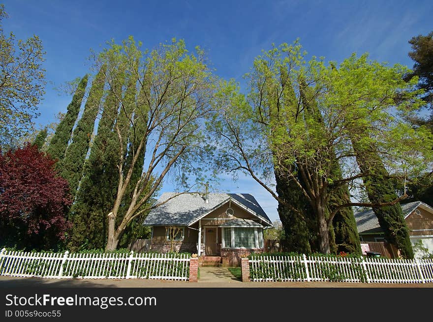 Wide angle view of a house with a white picket fence