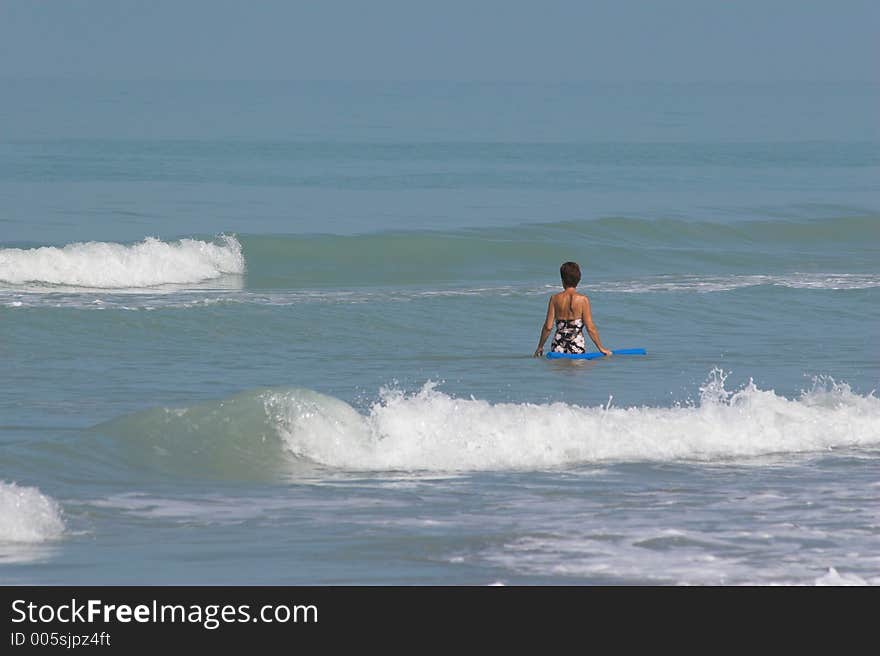 Beautiful woman enjoying day at the beach wading in the ocean. Beautiful woman enjoying day at the beach wading in the ocean