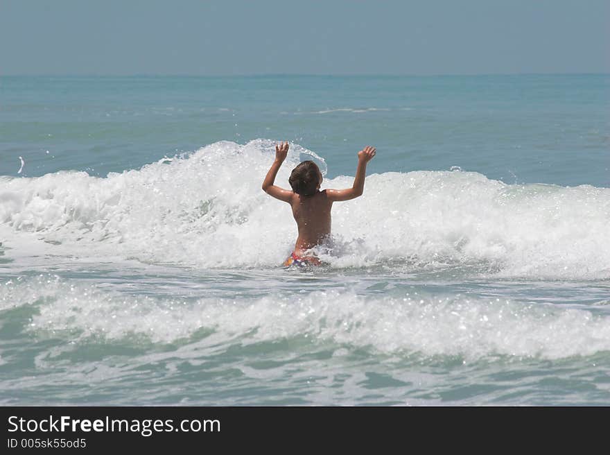 Young boy playing in the waves . Young boy playing in the waves