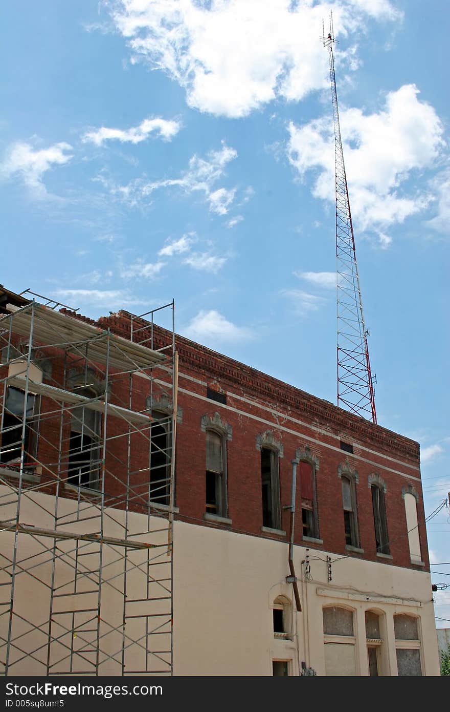 Demolition and renovation of old building with tower and sky in background. Demolition and renovation of old building with tower and sky in background