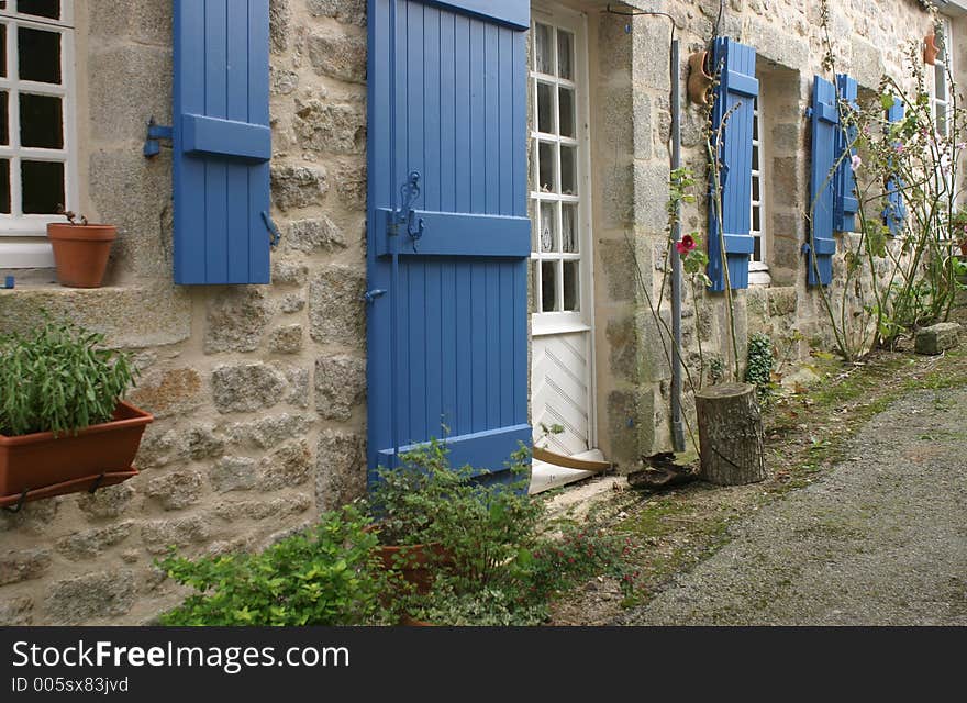 Narrow idyllic street, blue window blinds on the walls. Narrow idyllic street, blue window blinds on the walls