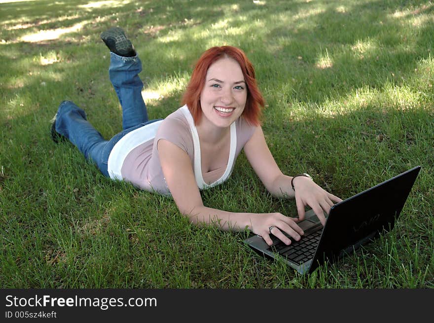 Pretty girl in park with laptop. Pretty girl in park with laptop.