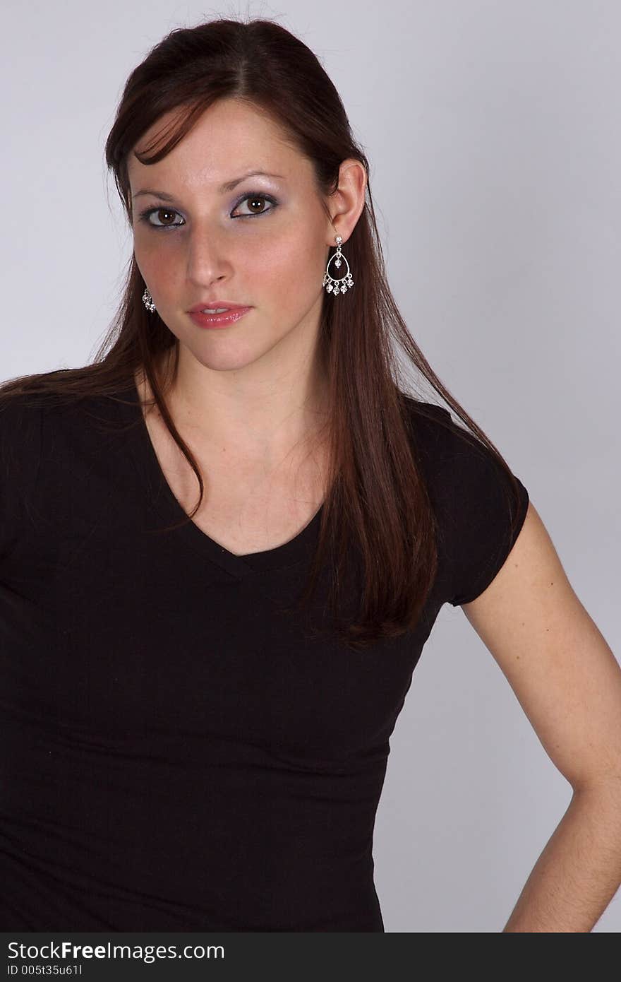 A young woman posing, smiling towards the camera. A young woman posing, smiling towards the camera