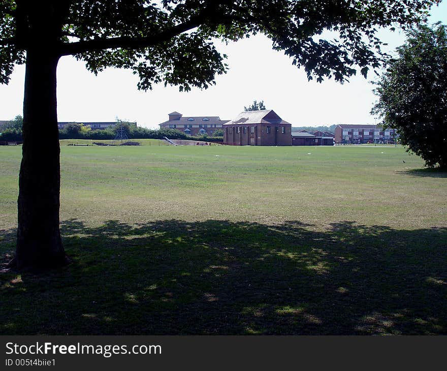 A hotel in a field in the outskirts of London under the shade of a tree