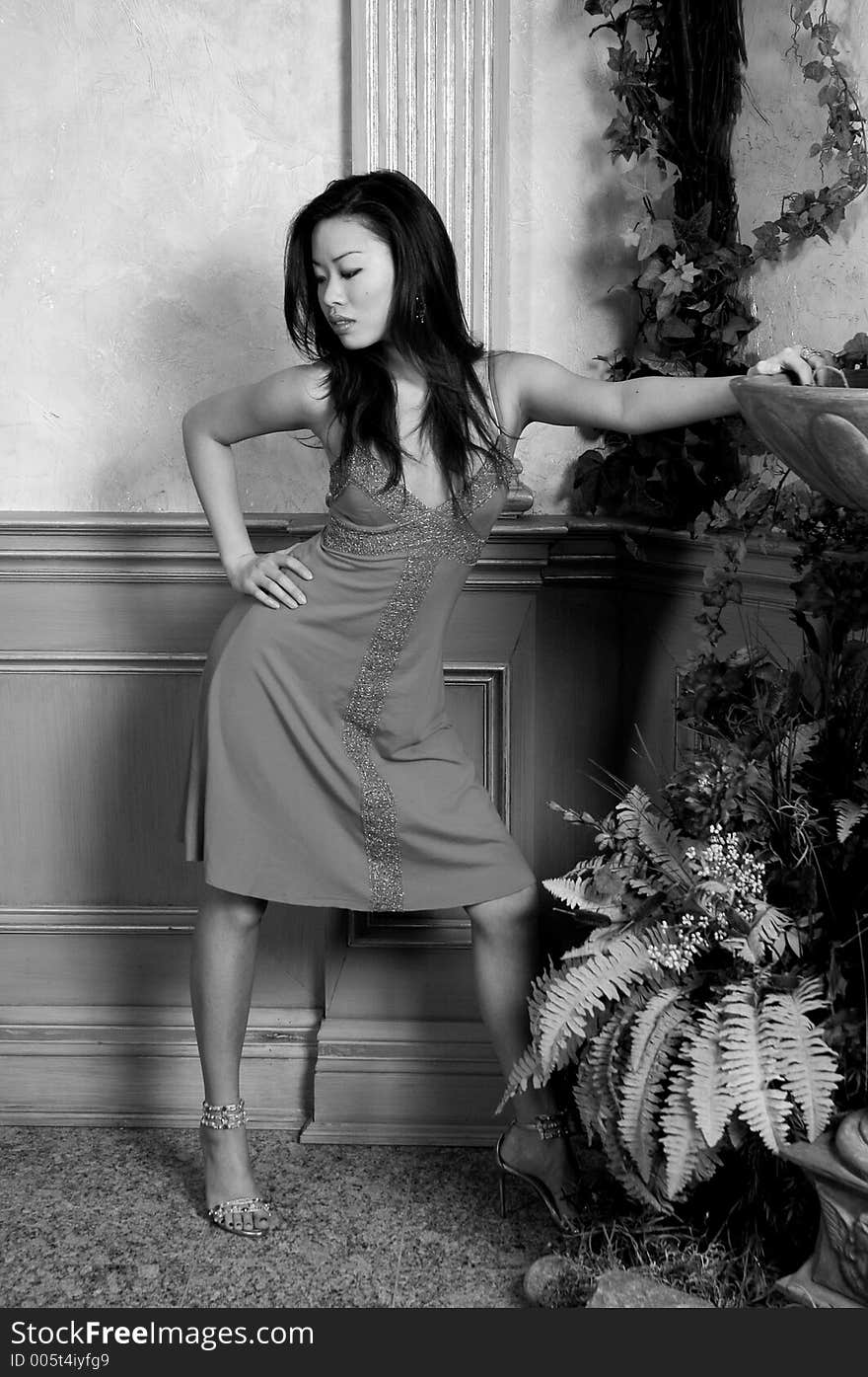 A black/white photo of a beautiful Asian model in an evening dress.