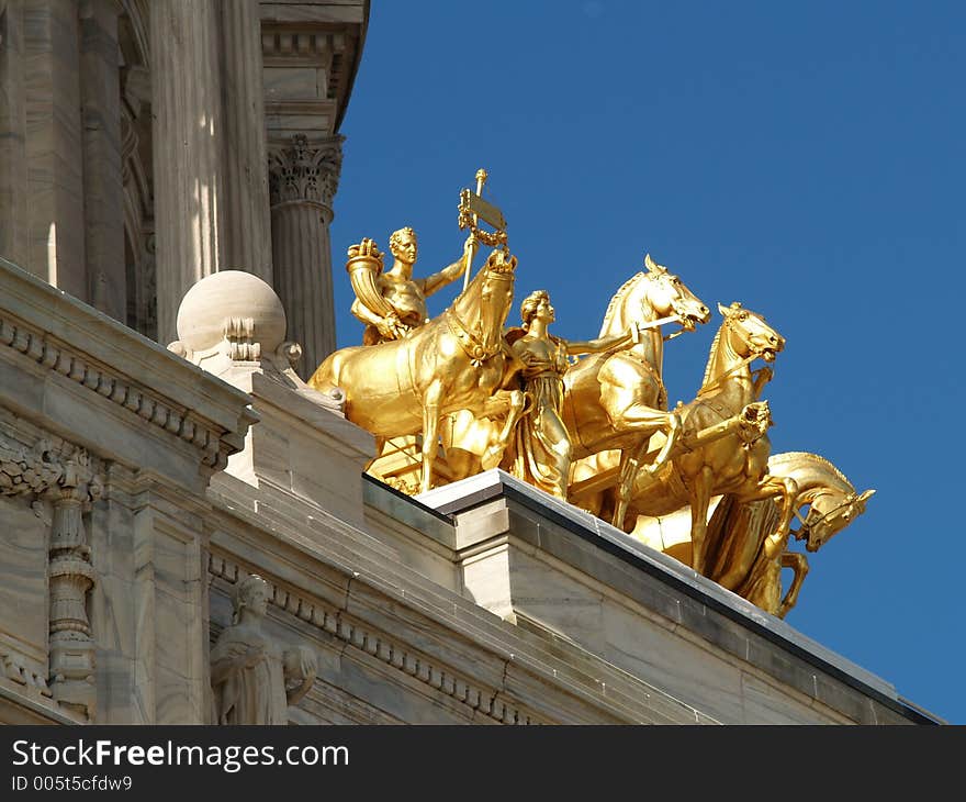 Low angle view of gold classical equestrian statues on historic building. Low angle view of gold classical equestrian statues on historic building.