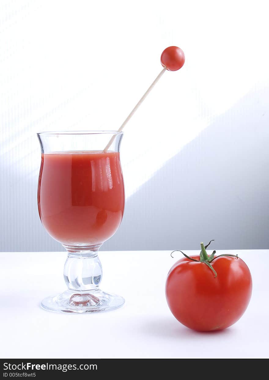 A glass of tomato juice and fresh tomato. A glass of tomato juice and fresh tomato