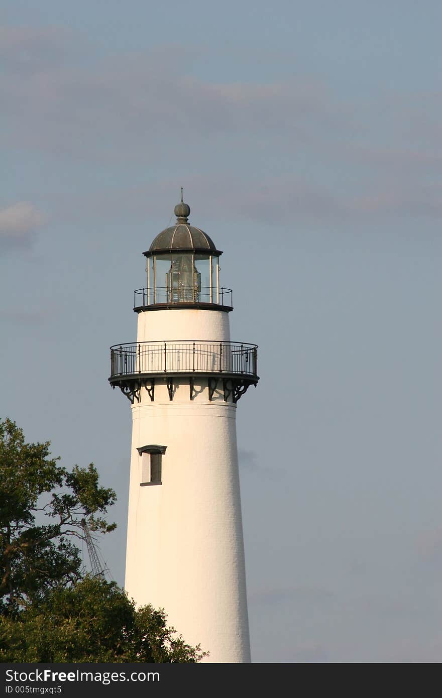 Lighthouse on coast with sky and trees in background. Lighthouse on coast with sky and trees in background