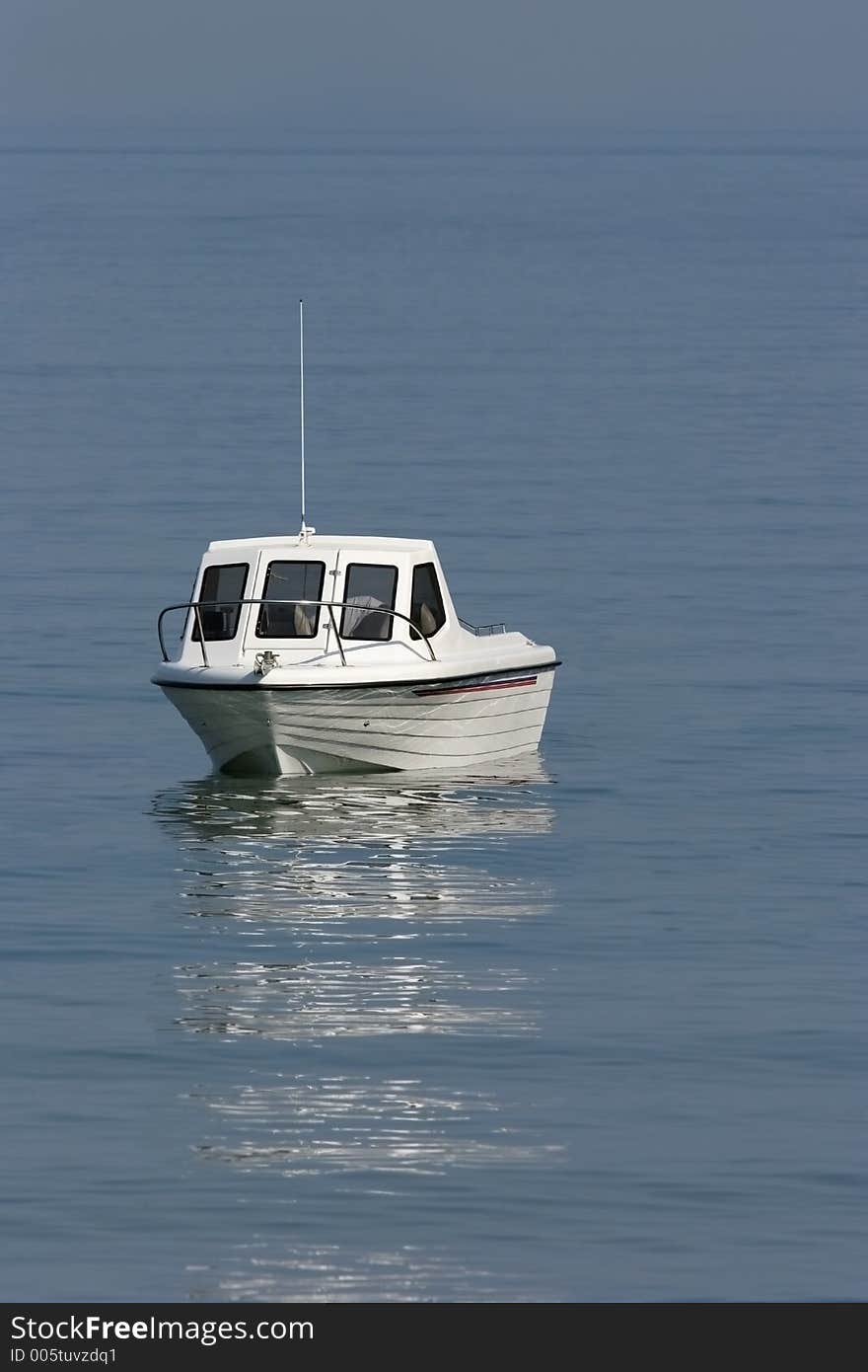 White motor cruiser on a calm blue sea. White motor cruiser on a calm blue sea.