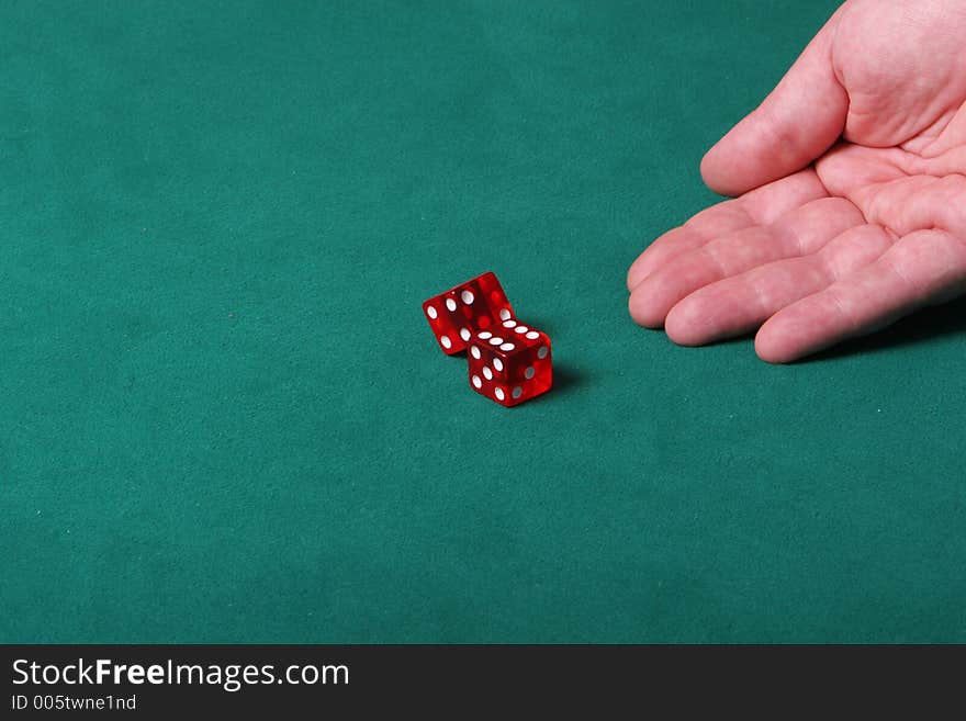 Dices being thrown in a craps game, or yatzee or any kind of dice involved game, Dices are a clear red color on a green felt table. Dices being thrown in a craps game, or yatzee or any kind of dice involved game, Dices are a clear red color on a green felt table