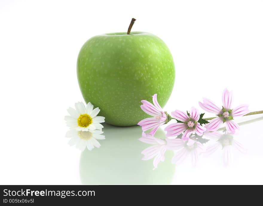 Green Apple isolated in a white background with flowers and reflection. Green Apple isolated in a white background with flowers and reflection