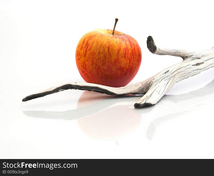 Red Apple isolated in a white background with piece of wood and reflection