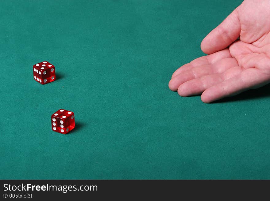 Dices being thrown in a craps game, or yatzee or any kind of dice involved game, Dices are a clear red color on a green felt table. Dices being thrown in a craps game, or yatzee or any kind of dice involved game, Dices are a clear red color on a green felt table