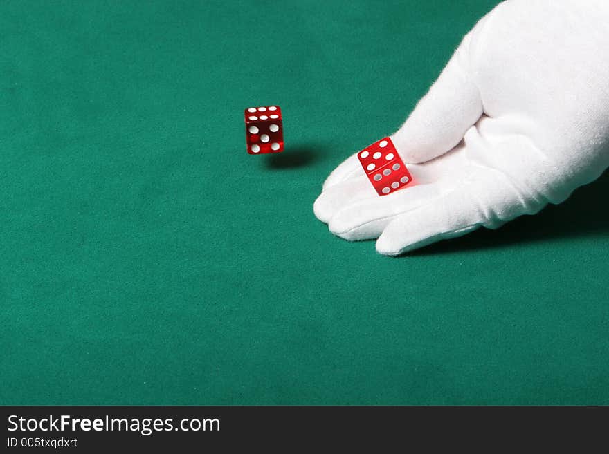 Dices being thrown in a craps game, or yatzee or any kind of dice involved game, Dices are a clear red color on a green felt table. Dices being thrown in a craps game, or yatzee or any kind of dice involved game, Dices are a clear red color on a green felt table