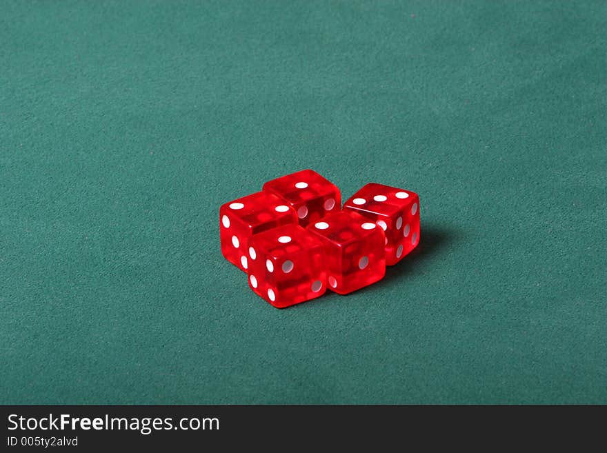 Dices being thrown in a craps game, or yatzee or any kind of dice involved game, Dices are a clear red color on a green felt table. Dices being thrown in a craps game, or yatzee or any kind of dice involved game, Dices are a clear red color on a green felt table