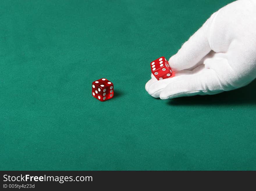 Dices being thrown in a craps game, or yatzee or any kind of dice involved game, Dices are a clear red color on a green felt table. Dices being thrown in a craps game, or yatzee or any kind of dice involved game, Dices are a clear red color on a green felt table