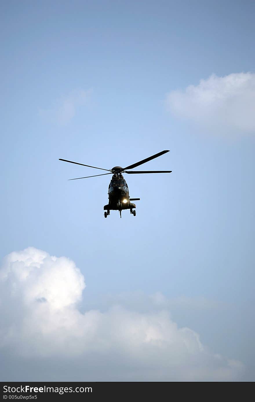 Army helicopter flying in a cloudy sky