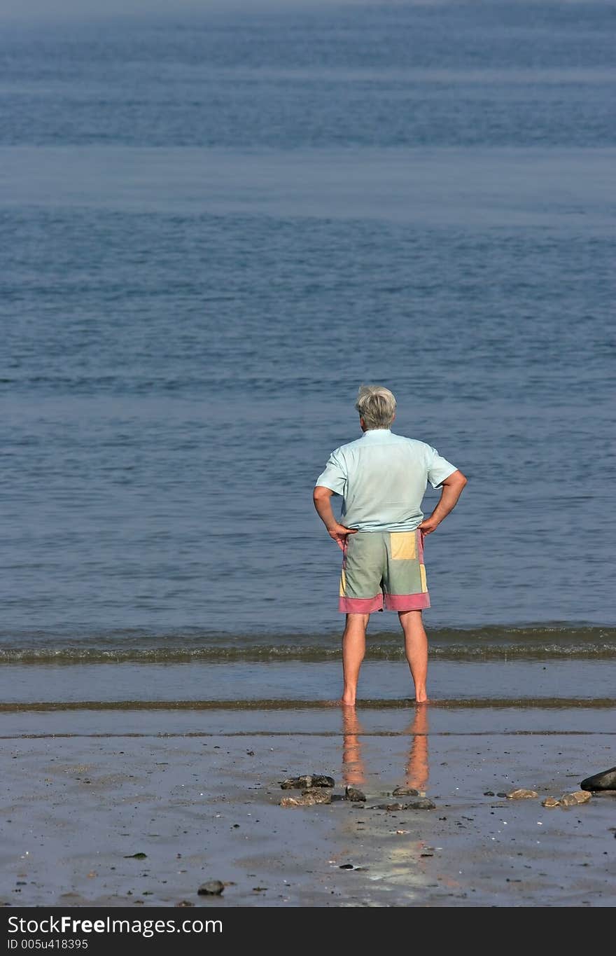 Elderly man at the beach , barefoot and paddling in the sea. Elderly man at the beach , barefoot and paddling in the sea.