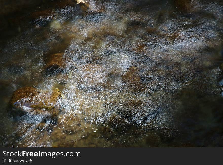 A slow shot of a stream revealing webs of fine traces of sunlight. A slow shot of a stream revealing webs of fine traces of sunlight.