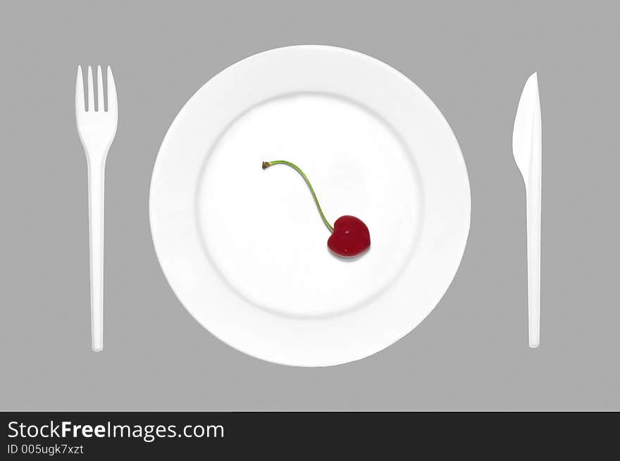 Cherry on the plate together with cutlery. Cherry on the plate together with cutlery