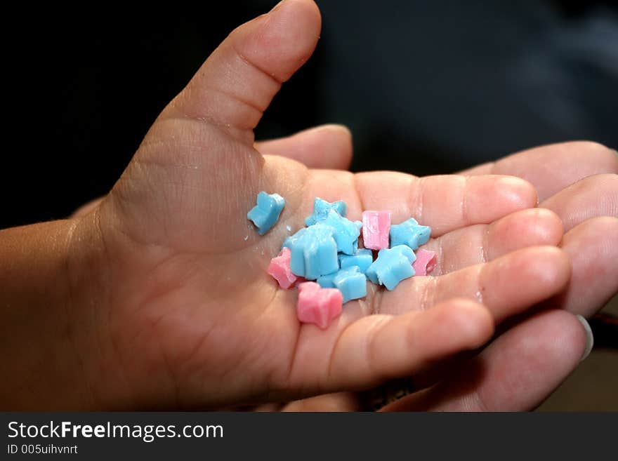 Young childs hand holding candy stars. Young childs hand holding candy stars.