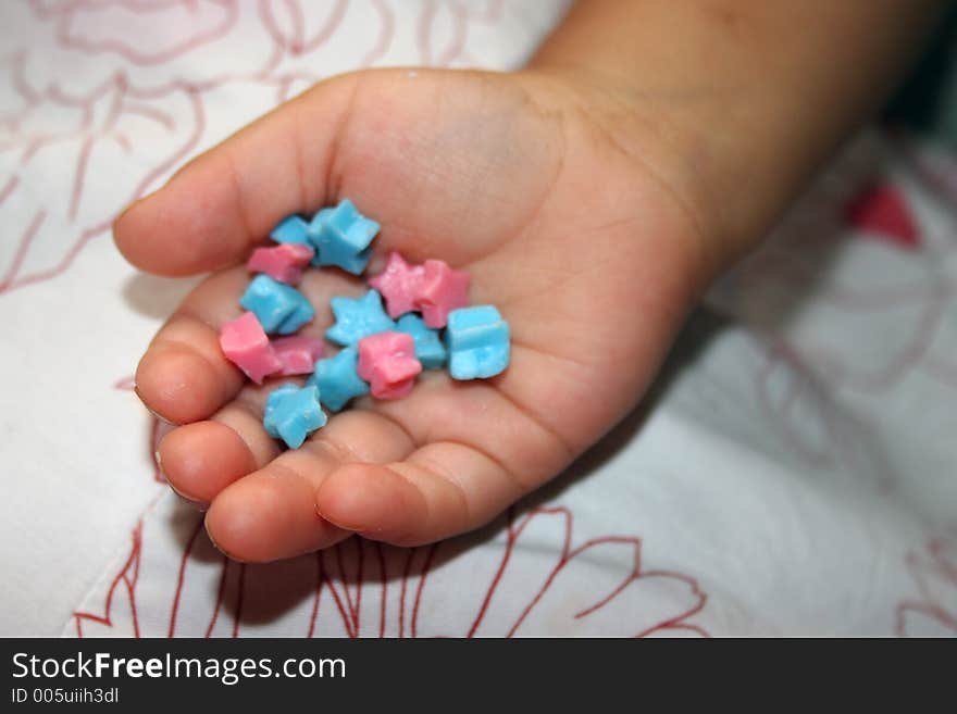 Young childs hand holding candy stars. Young childs hand holding candy stars