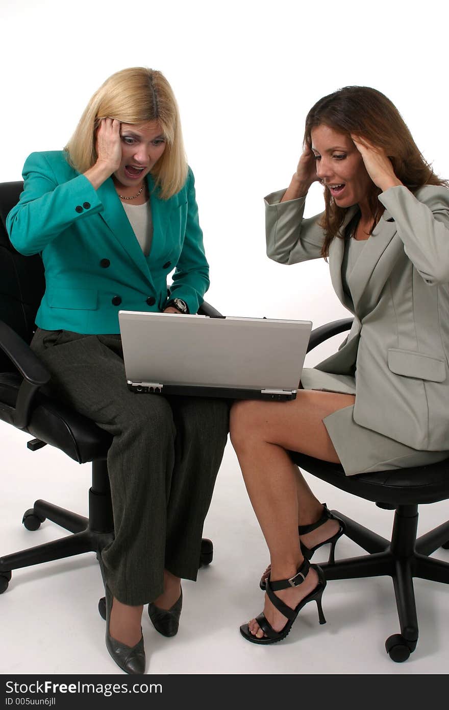 Attractive and beautiful two business woman team working at a laptop computer together. Shot on white. Attractive and beautiful two business woman team working at a laptop computer together. Shot on white.