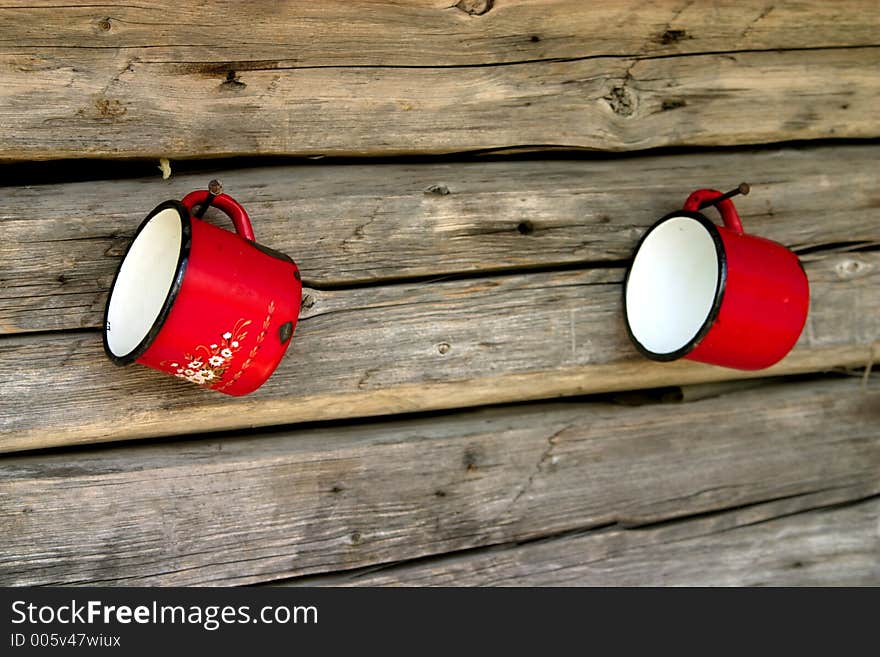 Metal red mugs hanging on the wood wall