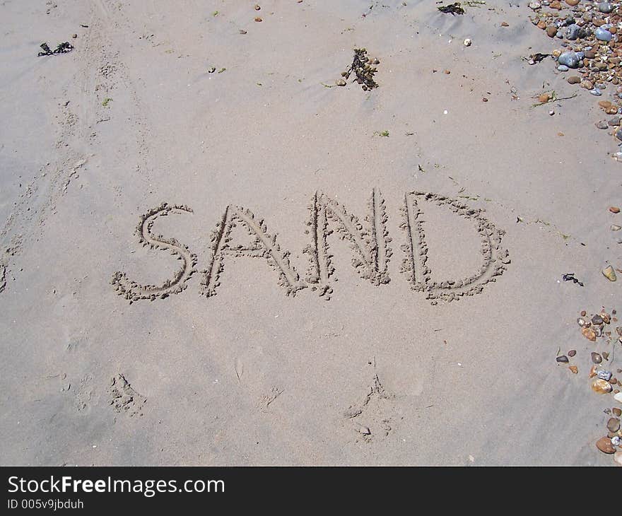 The word SAND written in sand