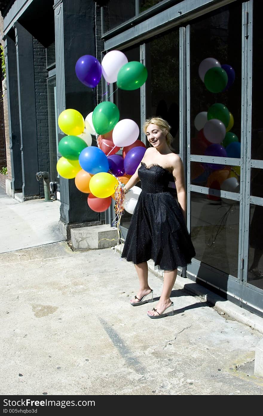 Young blond woman with balloons out on the street