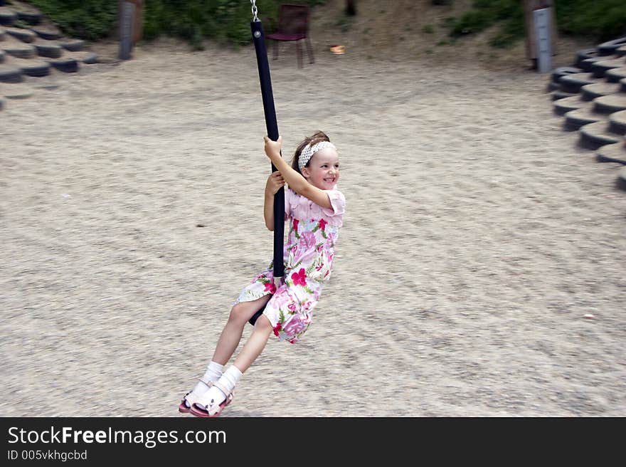 Young girl swinging on a playground. Young girl swinging on a playground